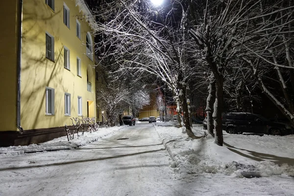 Kış gecesi çekimi. Çok katlı bir binanın avlusunda. Avlu ve ağaçlar karla kaplı. Rusya Telifsiz Stok Fotoğraflar