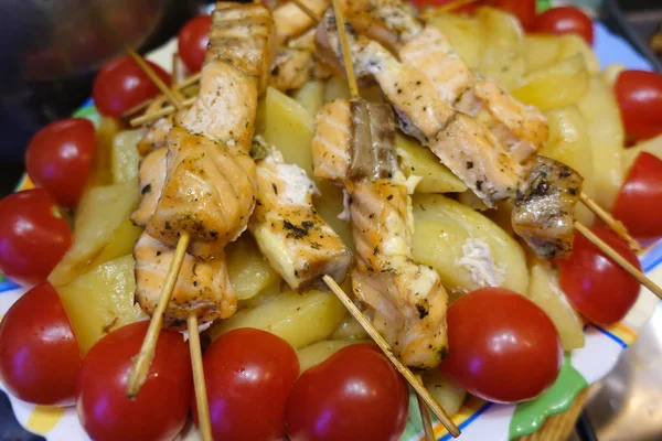 Salmon skewers on a plate with red tomatoes — Stock Photo, Image