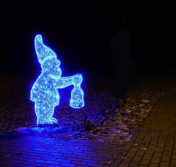 Weihnachtsfiguren auf hellen Girlanden. Weihnachten und Neujahr Winterurlaubsbeleuchtung. Girlanden leuchten. Girlande in Form einer Märchenfigur im Stadtpark. Festliches Lichterfest — Stockfoto