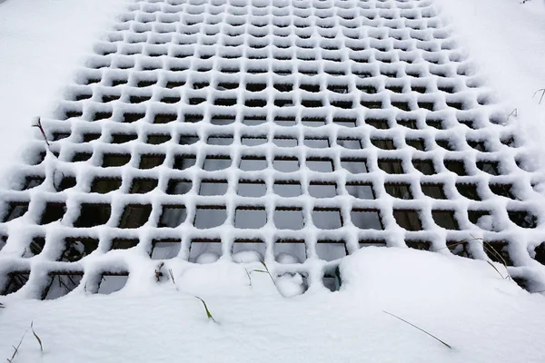 White fluffy snow formed a rhythmic pattern on the trellis. — Stock Photo, Image