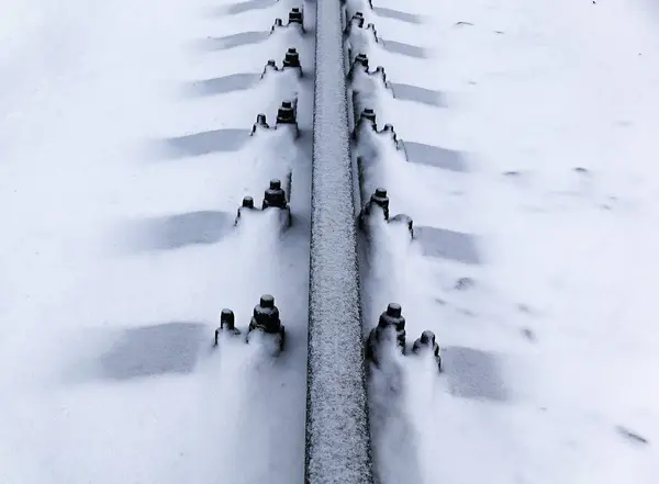 Laying the construction of new tram rails, snowy weather, rails and sleepers stretching into the distance covered with snow — Stock Photo, Image