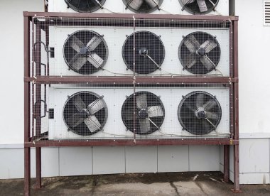 The air conditioning system is assembled on the side of the building. Many air conditioners are protected by mesh