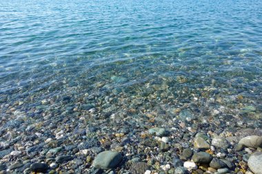 Çakıl taşı plajı. Deniz manzaralı. Sakin ve berrak suyla deniz kıyısı
