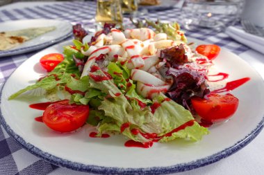 Farklı domatesli lezzetli salata, kırmızı biber, kuzu salatası, salatalık, marul ve kuzu salatası. Yaz salatası. Sağlıklı atıştırmalıklar. Lezzetli ve sağlıklı bir yemek konsepti. Beyaz ahşap arkaplan Kapat
