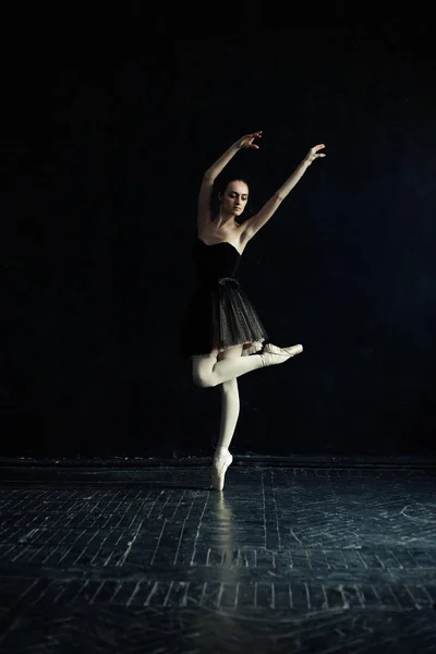 Bailarina em vestido preto no corredor escuro vazio . — Fotografia de Stock