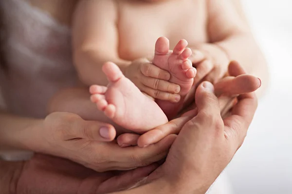 Los pies del bebé en las manos de madre y padre. De cerca. . — Foto de Stock