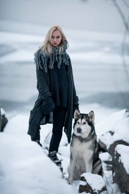 Köpek Malamute kış kayalarda arasında ile kız. 