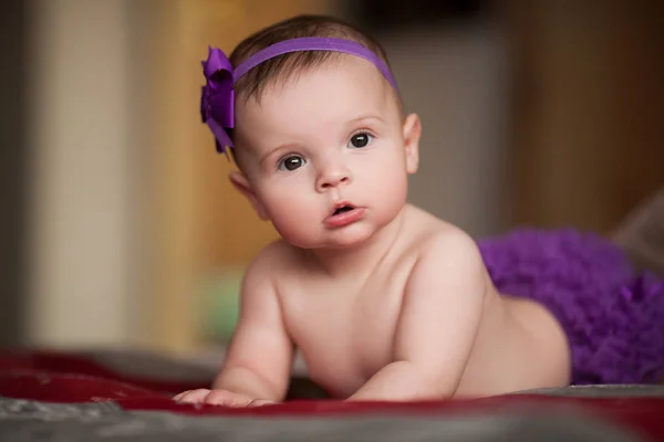 Retrato de niña pequeña con corona de cinta púrpura con flor en la cabeza . —  Fotos de Stock