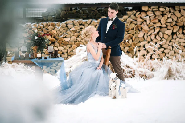 Zimní svatba venkovní na pozadí sněhu a palivového dříví. — Stock fotografie