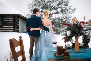 Arka planda karla kaplı ev ve köknar kış düğün açık havada.