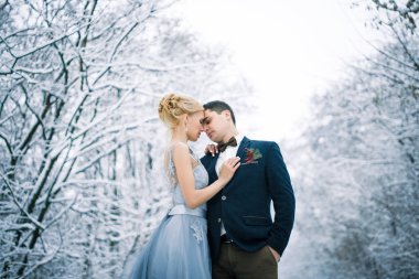 Gelin ve damat karlı ormanı arasında.