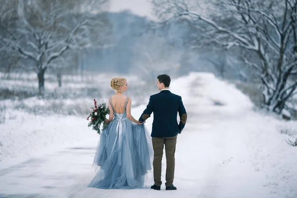 Bride and groom among snowy landscape. — Stock Photo, Image