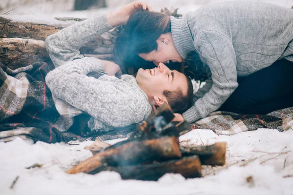 Jonge vrouw en man zijn voor roken vreugdevuur in winter pi — Stockfoto