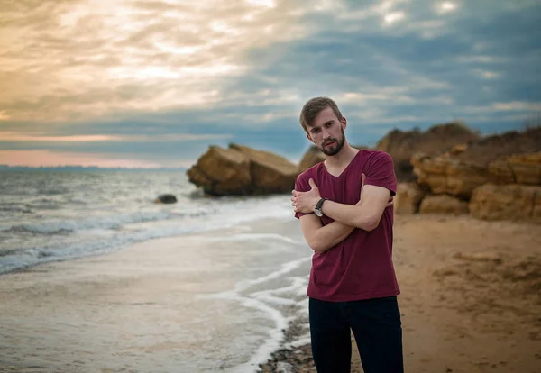 Chico en camiseta en la playa de invierno al atardecer . — Foto de Stock