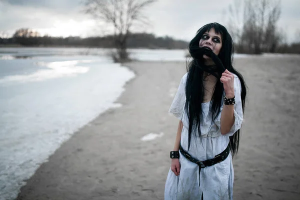 Pazzo giovane donna si trova sulla sabbia lungo il lago . — Foto Stock