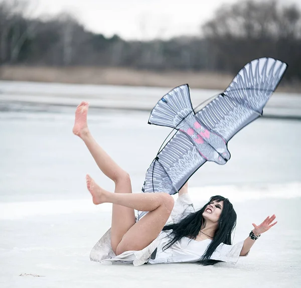 Pazzo giovane donna si trova sul lago di ghiaccio e tira i piedi con un kit — Foto Stock