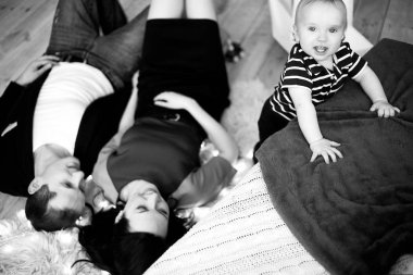 Yalan halı üzerine genç anne, Bebek ve yakındaki standları gülümsüyor.