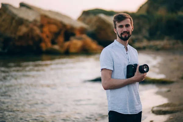 Joven fotógrafo masculino en la playa con cámara digital . — Foto de Stock