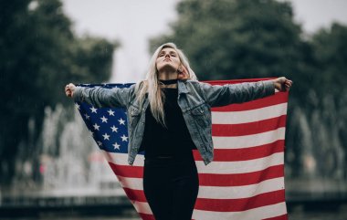 Genç kadın anlamına gelir ve bir Amerikan bayrağı tutar.