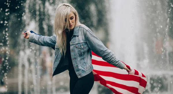 Молодая женщина с американским флагом на фоне фонтана . — стоковое фото