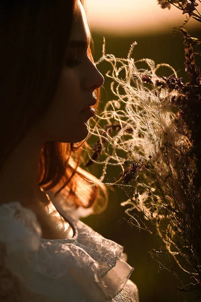 Portré, fiatal nő, fehér csipke ruha csokor vadvirágok. — Stock Fotó