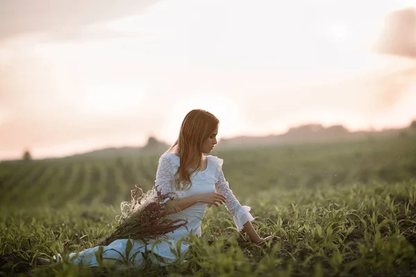 Jeune femme en longue robe en dentelle blanche sur champ de maïs . — Photo