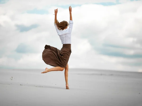 年轻的女人跳了沙漠中的沙. — 图库照片