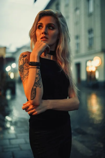Genç kadın portre dövme omuz ayakta şehir akşam sokak üzerinde olan. — Stok fotoğraf