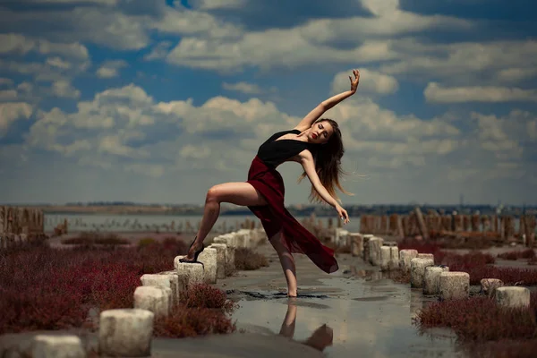 Ballerina sta ballando nella sabbia su sfondo spiaggia e cielo . — Foto Stock