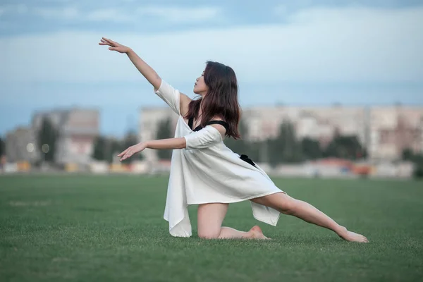 Ballerina sul prato sullo sfondo di edifici . — Foto Stock