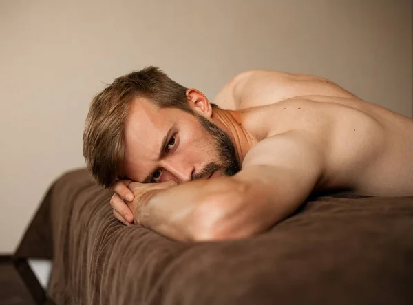 Retrato de un joven acostado en la cama en topless . —  Fotos de Stock