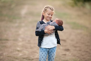Yeni doğan kardeşi yürüyüş ile kız çocuk. Yakın çekim.