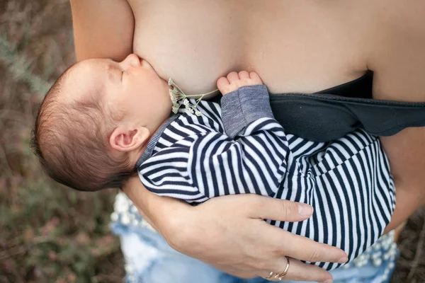 Giovane madre allattare al seno neonato a piedi. Da vicino. . — Foto Stock