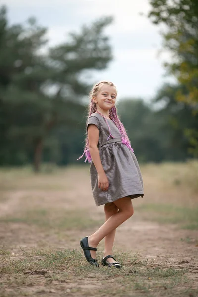 Boldog gyermek lány áll a séta a parkban. — Stock Fotó