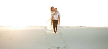 Damat gelini kumul çöl boyunca sırtında taşır.