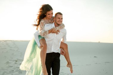 Damat gelini Kum Çölü'nde boyunca sırtında taşır. Yakın çekim.