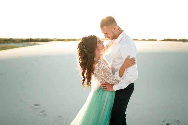 Menyasszony és a vőlegény állni sivatagban, mosoly, és ölelés. Közelről. — Stock Fotó