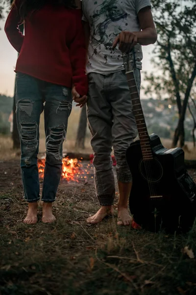 Verliefd paar staat met gitaar op picknick in het bos. — Stockfoto