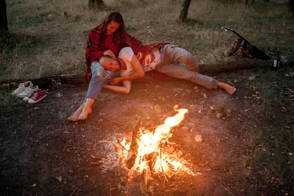 Couple amoureux sur pique-nique en forêt sur fond de flamme de feu de joie . — Photo