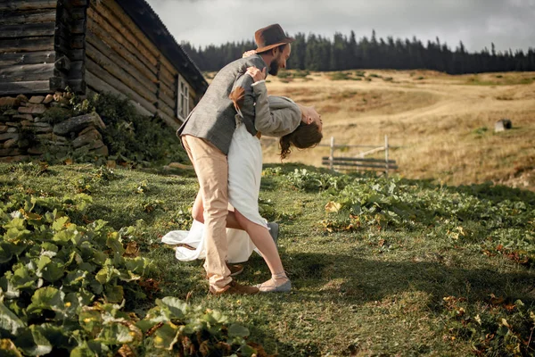 Recém-casados ficar, abraçar e se divertir no fundo do velho hu de madeira — Fotografia de Stock