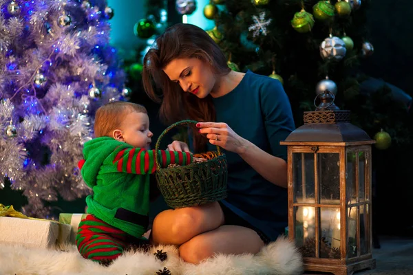彼女の幼い息子を見て枝編み細工品バスケットのクリスマス プレゼントで幸せな母. — ストック写真