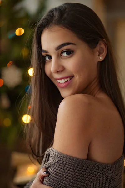 Portrait de belle jeune femme à épaule nue sur fond de lumières de Noël. Vue latérale . — Photo