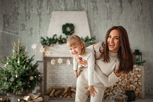 母と娘が楽しんで、クリスマスの装飾の背景と笑って. — ストック写真