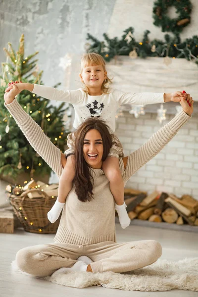 母と幼い娘を楽しんで、クリスマス ツリーや装飾品の背景と対戦. — ストック写真