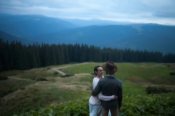 Mariée et marié debout et câlin sur fond de montagnes . — Photo