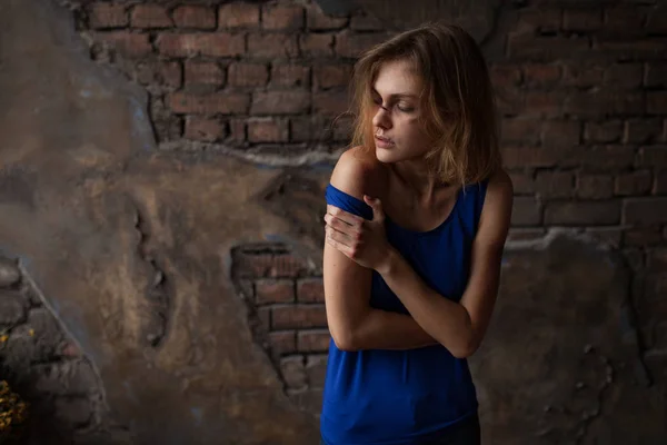 Mujer triste víctima de la violencia doméstica y el abuso se encuentra con moretones y heridas en su cara y cuerpo contra el fondo de la pared de ladrillo . —  Fotos de Stock