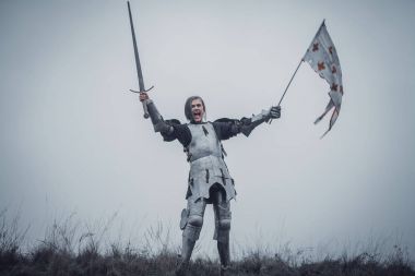 Kız Jeanne d'Arc görüntü zırh olarak duruyor ve savaş çığlığı onun elinde kılıç kaldırdı ve bayrak ile sorunları.