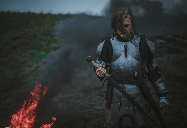 Jeanne d'Arc zırh ve onun elinde kılıçla görüntüsünü kız ateş ve duman arka planı standları. — Stok fotoğraf