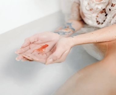 Kadının elinde su ile küvet onun avuç içi Japon balığı tutun. Portre.