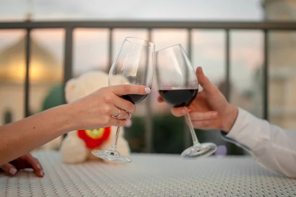 Las manos masculinas y femeninas tintinean por las gafas de vino en la cafetería. Primer plano. . — Foto de Stock